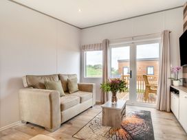 A living room with seating and glass doors at Kinder Spa (Pet) Carlton Miniott near Thirsk