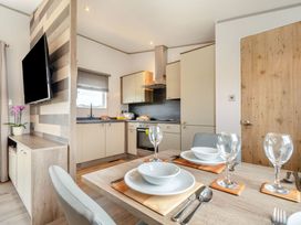 A kitchen with a dining table set and a television at Kinder Spa (Pet) Carlton Miniott near Thirsk