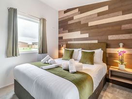 A bedroom with a bed and curtains at Kinder Spa (Pet) Carlton Miniott near Thirsk