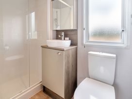 A bathroom with a sink, toilet, and shower at Kinder Spa (Pet) Carlton Miniott near Thirsk