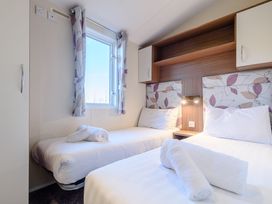 A bedroom with two beds and a window at Alder Spa (Pet) Carlton Miniott near Thirsk