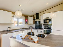 A kitchen with a stove and sink at Oak Waterside Spa Carlton Miniott near Thirsk