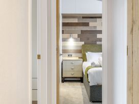 A bedroom with a bed and bedside table at Oak Waterside Spa in Carlton Miniott near Thirsk