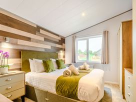 A bedroom with a bed and a window at Oak Waterside Spa Carlton Miniott near Thirsk