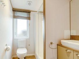 A bathroom with a toilet and a shower at Oak Waterside Spa Carlton Miniott near Thirsk