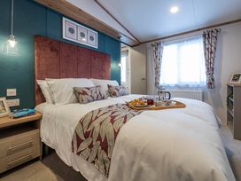 A bedroom with a bed and breakfast set on a tray at Redwood Waterside Spa Carlton Miniott near Thirsk