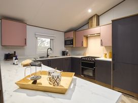 A kitchen with countertop, stove, cabinets and utensils at Laurel Spa Carlton Miniott near Thirsk