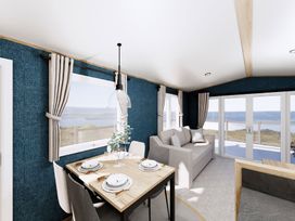 A dining room with a table and sofa at Willow Spa near Carlton Miniott