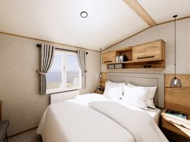 A bedroom with a bed and wooden shelves at Willow Waterside Spa Carlton Miniott near Thirsk