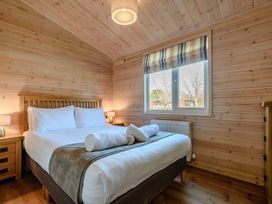 A bedroom with a bed and bedside table at Fir Tree Waterside Spa Carlton Miniott near Thirsk