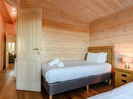 A bedroom with a bed and a bedside table at Fir Tree Waterside Spa Carlton Miniott near Thirsk