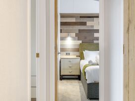 A bedroom with a bed and nightstand at Spindle Spa Carlton Miniott near Thirsk