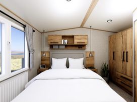 A bedroom with a bed and a wardrobe at Oak Spa (Pet) Carlton Miniott near Thirsk