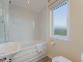 A bathroom with a bathtub and a window at Oak Spa (Pet) Carlton Miniott near Thirsk