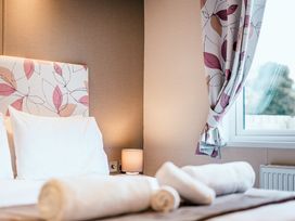 A bedroom with a bed and lamp at Oak Spa (Pet) Carlton Miniott near Thirsk