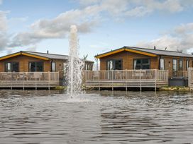 Two cabins next to a fountain at Oak Waterside Spa (Pet) Carlton Miniott near Thirsk