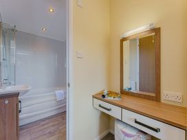 A bathroom with a sink, bath tub, and a vanity unit at Oak Waterside Spa (Pet) Carlton Miniott near Thirsk