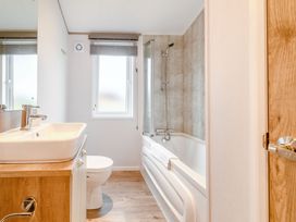 A bathroom with a sink, toilet, and bathtub at Oak Waterside Spa (Pet) Carlton Miniott near Thirsk