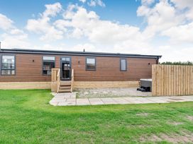 An outdoor view of a mobile home with steps and a fence at Beech Waterside Spa Carlton Miniott near Thirsk