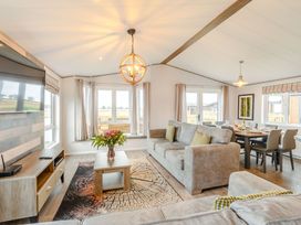 A living room with a sofa and dining area at Beech Waterside Spa Carlton Miniott near Thirsk