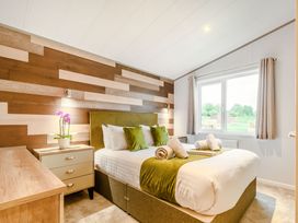 A bedroom with a bed and bedside table at Beech Waterside Spa Carlton Miniott near Thirsk