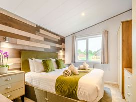 A bedroom with a bed and window at Beech Waterside Spa Carlton Miniott near Thirsk