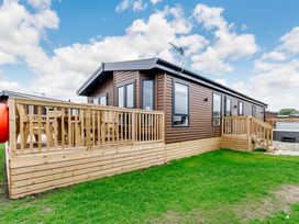 A cabin with wooden decking and steps at Beech Waterside Spa (Pet) Carlton Miniott near Thirsk