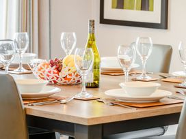 A dining table set with plates, glasses, and a fruit bowl at Beech Waterside Spa (Pet) Carlton Miniott near Thirsk