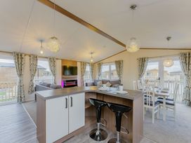 A living room with a kitchen island and dining area at Larch Waterside Spa (Pet) Carlton Miniott near Thirsk