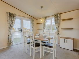 A dining room with a table and chairs at Larch Waterside Spa (Pet) Carlton Miniott near Thirsk