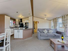 A living room with a sofa and dining table in Larch Waterside Spa (Pet) Carlton Miniott near Thirsk