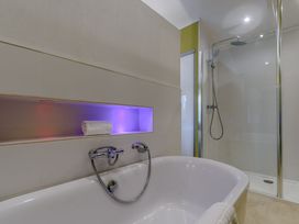 A bathroom with a bathtub and shower area at Cherry Tree in Carlton Miniott near Thirsk
