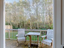 An outdoor area with wooden chairs and table at Cherry Tree in Carlton Miniott near Thirsk