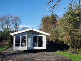 A cabin surrounded by trees at Plas Marchog Lodge in Pentraeth