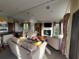 A living room with a sofa and a coffee table at Plas Marchog Lodge in Pentraeth