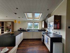 A kitchen with sink and stove at Plas Marchog Lodge in Pentraeth