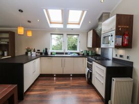A kitchen with counter, sink, and stove at Plas Marchog Lodge Rhoscefnhir near Pentraeth