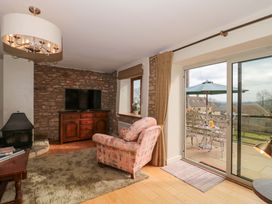 A living room with a television and sofa at Daisy Bank in Maugersbury near Stow-On-The-Wold