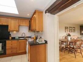 A kitchen with cabinets, sink, and dining area at Daisy Bank in Maugersbury near Stow-On-The-Wold