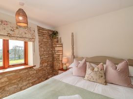 A bedroom with a bed and window at Daisy Bank in Maugersbury near Stow-On-The-Wold