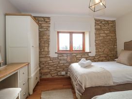 A bedroom with a bed and a window at Daisy Bank in Maugersbury near Stow-On-The-Wold