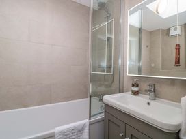 A bathroom with a bathtub, shower, and sink at Daisy Bank in Maugersbury near Stow-On-The-Wold