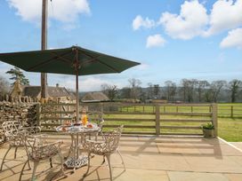 An outdoor patio with a table and chairs at Daisy Bank in Maugersbury near Stow-On-The-Wold