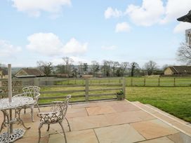 An outdoor area with a table and chairs overlooking a field at Daisy Bank in Maugersbury near Stow-On-The-Wold