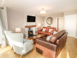 A living room with a sofa, armchairs, and a fireplace at Dunholme
