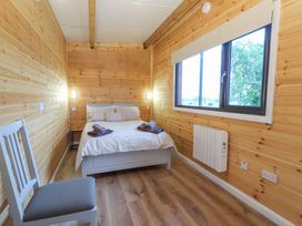 A bedroom with a bed and a chair at Killinure Cottage in Glasson, County Westmeath