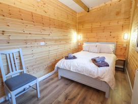 A bedroom with a bed and chair at Killinure Cottage in Glasson, County Westmeath