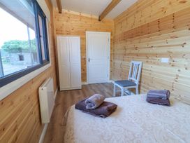 A bedroom with a bed and a chair at Killinure Cottage, Glasson, County Westmeath
