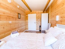 A bedroom with a bed, towels, and wardrobe at Killinure Cottage, Glasson, County Westmeath