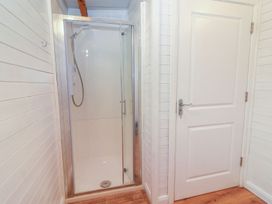 A bathroom with a shower and a door at Killinure Cottage in Glasson, County Westmeath
